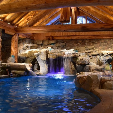 Indoor pool with massive boulder waterfall and slide