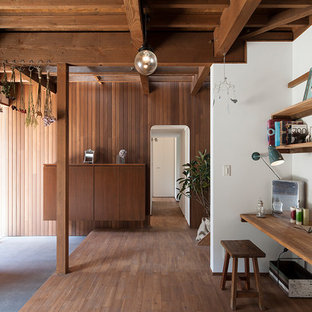 東京23区の片開きドアモダンスタイルのおしゃれなマッドルーム (マルチカラーの壁、コンクリートの床、木目調のドア、グレーの床) の写真