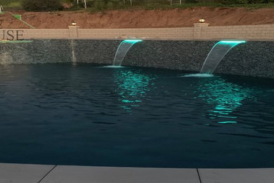 Inspiration for a large tropical backyard concrete paver and custom-shaped pool remodel in San Diego