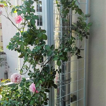 Terrazzo con fioriere, panca e arredi per una famiglia a Milano