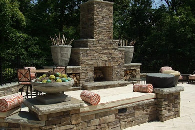 Example of a large arts and crafts backyard stone patio design in Nashville with a fire pit