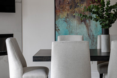 Photo of a mid-sized contemporary separate dining room in Toronto with beige walls, medium hardwood floors, a corner fireplace, a concrete fireplace surround and brown floor.