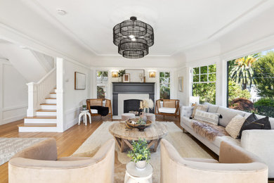 Inspiration for a large transitional enclosed light wood floor, beige floor and coffered ceiling living room remodel in San Francisco with white walls, a standard fireplace and a concrete fireplace