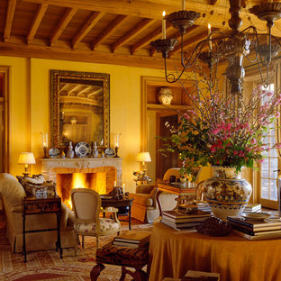 Imagen de salón para visitas cerrado, mediterráneo, sin televisor, con paredes amarillas, chimenea tradicional y marco de chimenea de piedra