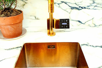 Photo of a contemporary kitchen with a belfast sink, marble worktops, multi-coloured splashback, marble splashback, coloured appliances and multicoloured worktops.
