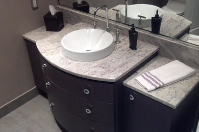 Mid-sized trendy 3/4 ceramic tile and gray floor bathroom photo in Chicago with furniture-like cabinets, dark wood cabinets, gray walls, a vessel sink and granite countertops