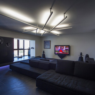 Design ideas for a large contemporary open plan home cinema in Other with white walls, slate flooring, a wall mounted tv and black floors.