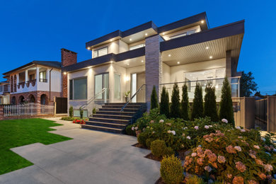 Example of a large trendy white three-story stucco exterior home design in Vancouver with a black roof