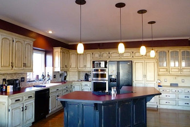 Large eclectic u-shaped eat-in kitchen photo in Kansas City with raised-panel cabinets, distressed cabinets and an island