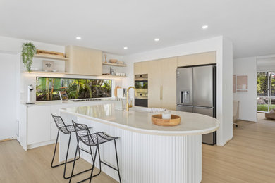 Design ideas for a large scandinavian l-shaped kitchen pantry in Gold Coast - Tweed with stainless steel appliances, an undermount sink, flat-panel cabinets, light wood cabinets, quartz benchtops, white splashback, window splashback, vinyl floors, with island, beige floor, white benchtop and recessed.