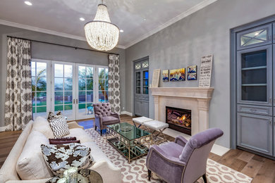 Inspiration for a mid-sized transitional medium tone wood floor living room remodel in Phoenix with gray walls, a standard fireplace, a stone fireplace and no tv