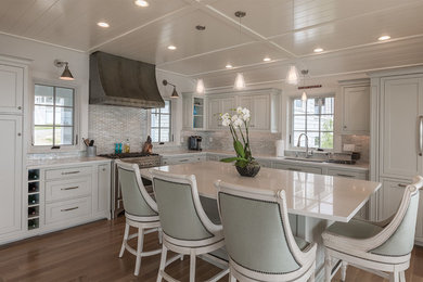 Example of a large classic l-shaped medium tone wood floor open concept kitchen design in Boston with an undermount sink, recessed-panel cabinets, green cabinets, ceramic backsplash, stainless steel appliances and an island