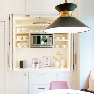Foto di un angolo bar minimal di medie dimensioni con ante lisce, ante bianche, top in quarzo composito, paraspruzzi bianco, paraspruzzi in quarzo composito, pavimento in legno massello medio, pavimento marrone e top bianco