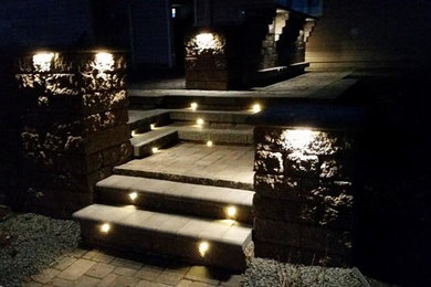 Design ideas for a large modern partial sun backyard concrete paver landscaping in Other with a fire pit.