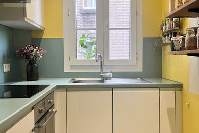 Cette image montre une cuisine minimaliste de taille moyenne avec une crédence bleue.