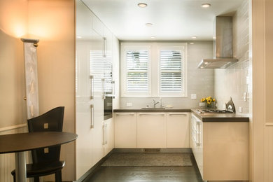 Inspiration for a small modern u-shaped dark wood floor eat-in kitchen remodel in Santa Barbara with an undermount sink, flat-panel cabinets, white cabinets, wood countertops, white backsplash, subway tile backsplash, stainless steel appliances and no island