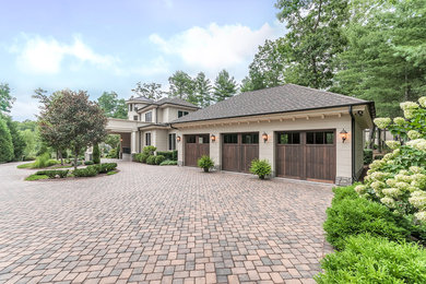 Inspiration for a large timeless beige two-story stucco exterior home remodel in Other with a hip roof