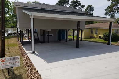 Example of a huge minimalist gray three-story concrete fiberboard house exterior design in Houston with a hip roof and a shingle roof