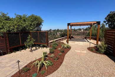 Design ideas for a contemporary drought-tolerant and full sun backyard decomposed granite and wood fence landscaping in San Diego with a pergola for summer.