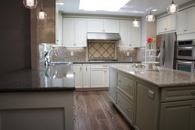 Inspiration for a mid-sized transitional u-shaped medium tone wood floor and brown floor eat-in kitchen remodel in San Francisco with raised-panel cabinets, white cabinets, quartz countertops, beige backsplash, an island, an undermount sink, stainless steel appliances, mosaic tile backsplash and beige countertops