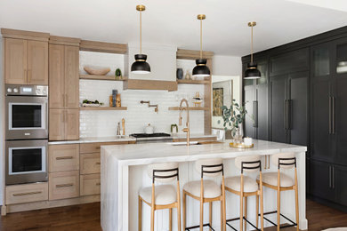 Example of a huge arts and crafts l-shaped dark wood floor and brown floor open concept kitchen design in New York with an undermount sink, recessed-panel cabinets, black cabinets, marble countertops, white backsplash, ceramic backsplash, paneled appliances, an island and white countertops