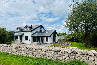 Photo of a medium sized contemporary two floor render and front house exterior in Other with a pitched roof, a tiled roof and a blue roof.