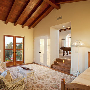 Mid-sized tuscan guest medium tone wood floor bedroom photo in Santa Barbara with yellow walls and no fireplace