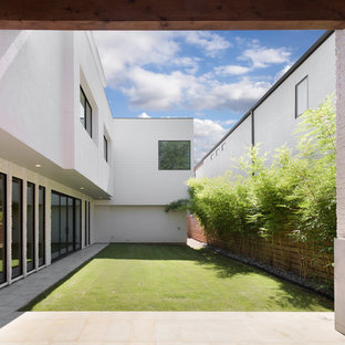 This is an example of a contemporary backyard partial sun garden in Houston with concrete pavers and with fireplace.