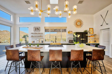 Example of a trendy single-wall ceramic tile, brown floor and vaulted ceiling eat-in kitchen design in Los Angeles with an undermount sink, flat-panel cabinets, green cabinets, quartz countertops, white backsplash, stone slab backsplash, colored appliances, an island and white countertops