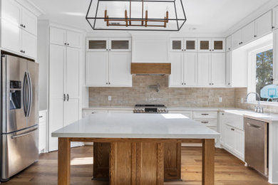Large 1960s u-shaped eat-in kitchen photo in Houston with a farmhouse sink, shaker cabinets, white cabinets, quartz countertops, beige backsplash, porcelain backsplash, stainless steel appliances, an island and white countertops
