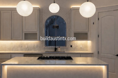 Inspiration for a contemporary u-shaped eat-in kitchen remodel with shaker cabinets, quartzite countertops, beige backsplash, porcelain backsplash, an island and white countertops