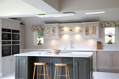 Medium sized modern l-shaped open plan kitchen in Other with recessed-panel cabinets, green cabinets, quartz worktops and white worktops.