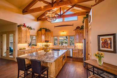 Inspiration for a southwestern vinyl floor and brown floor kitchen remodel in Other with raised-panel cabinets, granite countertops, stainless steel appliances and an island