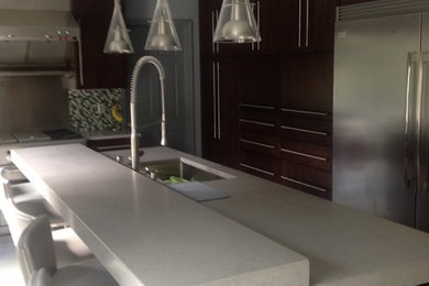 Example of a mid-sized trendy l-shaped porcelain tile eat-in kitchen design in Boston with a single-bowl sink, flat-panel cabinets, dark wood cabinets, quartz countertops, multicolored backsplash, ceramic backsplash, stainless steel appliances and an island