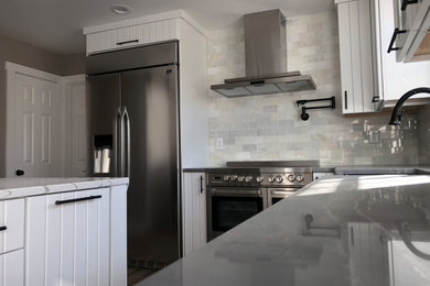 Example of a mid-sized country l-shaped porcelain tile and brown floor eat-in kitchen design in DC Metro with a farmhouse sink, shaker cabinets, quartz countertops, marble backsplash, stainless steel appliances, an island and white countertops