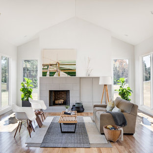 Idee per un piccolo soggiorno minimal aperto con pareti bianche, parquet chiaro, camino classico, cornice del camino piastrellata, TV nascosta e pavimento beige