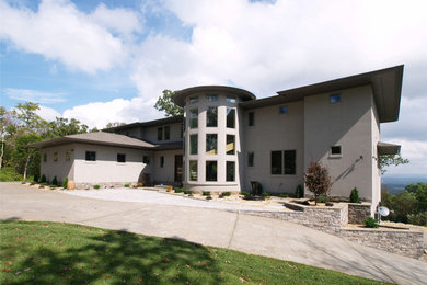 This is an example of a contemporary two-storey stucco exterior in Other with a hip roof.