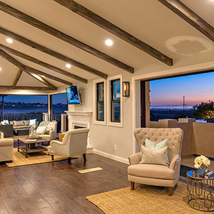 Großes, Offenes Mediterranes Wohnzimmer mit grauer Wandfarbe, dunklem Holzboden, Kamin und Kaminsims aus Holz in San Diego