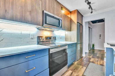 Minimalist laminate floor and brown floor kitchen pantry photo in Vancouver with medium tone wood cabinets, quartzite countertops, white backsplash, ceramic backsplash, stainless steel appliances and white countertops