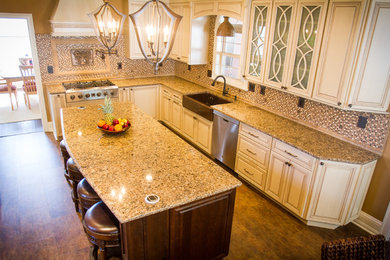 Example of a large transitional u-shaped vinyl floor eat-in kitchen design in New York with a farmhouse sink, raised-panel cabinets, distressed cabinets, granite countertops, multicolored backsplash, mosaic tile backsplash, stainless steel appliances and an island