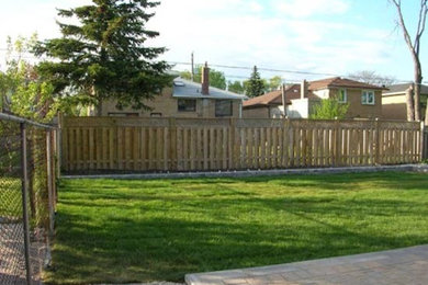 Photo of a mid-sized full sun backyard brick landscaping in Toronto.