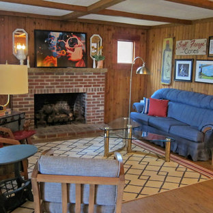 Photo of a medium sized romantic walk-out basement in Nashville with brown walls, medium hardwood flooring, a standard fireplace, a brick fireplace surround and brown floors.