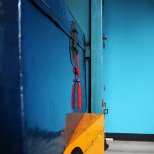 Immagine di una camera matrimoniale etnica di medie dimensioni con pareti blu e pavimento in laminato