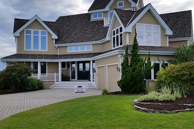 Large elegant brown three-story wood exterior home photo in Baltimore with a shingle roof