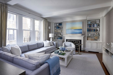 Example of a beach style enclosed medium tone wood floor and brown floor living room design in Raleigh with gray walls and a standard fireplace