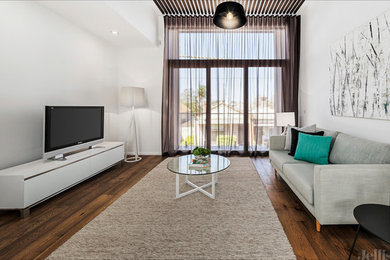 Mid-sized contemporary open concept living room in Melbourne with white walls, medium hardwood floors and a freestanding tv.