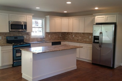 Inspiration for a mid-sized timeless l-shaped dark wood floor open concept kitchen remodel in New York with an undermount sink, shaker cabinets, white cabinets, granite countertops, brown backsplash, subway tile backsplash, stainless steel appliances and an island