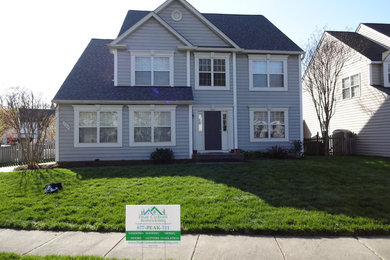 Large traditional blue two-story vinyl exterior home idea in Baltimore with a shingle roof