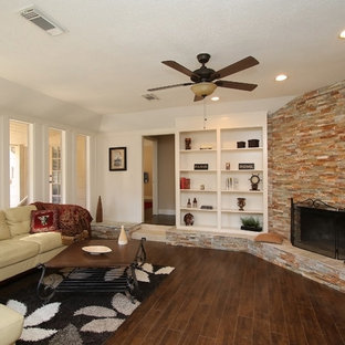 Mittelgroßes, Repräsentatives, Fernseherloses, Abgetrenntes Mediterranes Wohnzimmer mit weißer Wandfarbe, Laminat, Eckkamin, Kaminsims aus Stein und braunem Boden in Houston