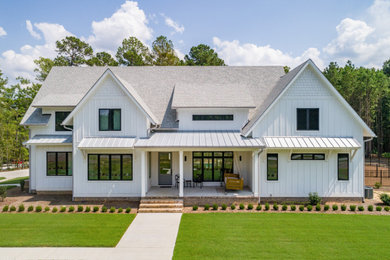 Large country white two-story board and batten exterior home photo in Raleigh with a shingle roof and a gray roof